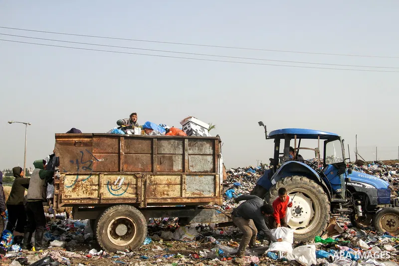 Palestinian children collect scrap from a garbage dump in the Bedouin village of "Umm Al-Nasr" in the northern Gaza Strip, on December 9, 2020. When the COVID-19 pandemic struck worldwide, humanitarian organizations in t...