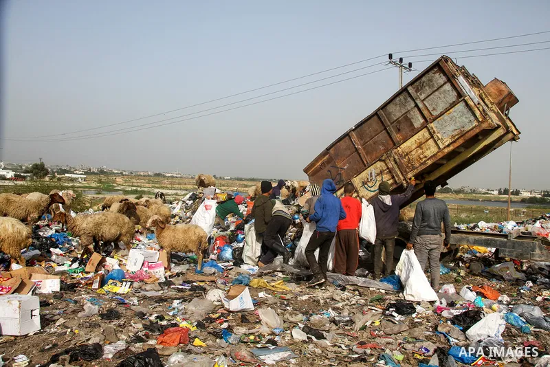 Palestinian children collect scrap from a garbage dump in the Bedouin village of "Umm Al-Nasr" in the northern Gaza Strip, on December 9, 2020. When the COVID-19 pandemic struck worldwide, humanitarian organizations in t...