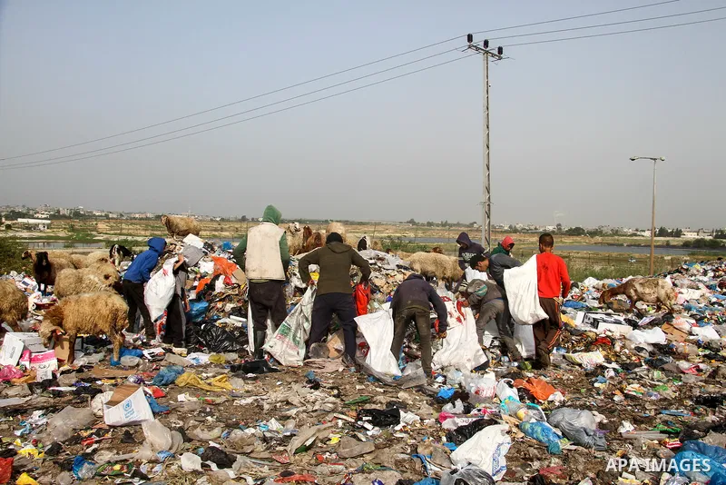Palestinian children collect scrap from a garbage dump in the Bedouin village of "Umm Al-Nasr" in the northern Gaza Strip, on December 9, 2020. When the COVID-19 pandemic struck worldwide, humanitarian organizations in t...