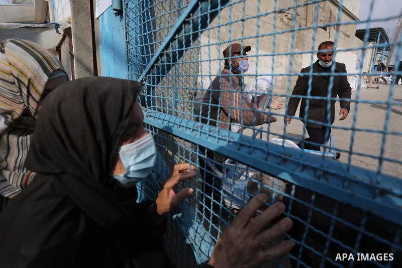 Palestinians wearing face masks, take part in a protest against the reduction of the food basket provided by the United Nations Relief and Works Agency for Palestine Refugees (UNRWA), in front of the UNRWA aid distributi...