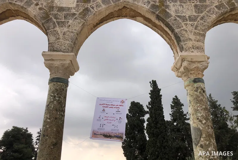 A picture taken on November 6, 2020, shows an awareness banner to limit the spread of the coronavirus among worshipers in Jerusalem's Old City. Photo by Abdalrahman nader Alami
