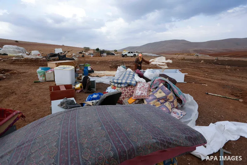 Palestinian bedouins stand next to their belongings after Israeli soldiers demolished their tents in an area east of the village of Tubas, in the West Bank, on November 3, 2020. Photo by Shadi Jarar'ah