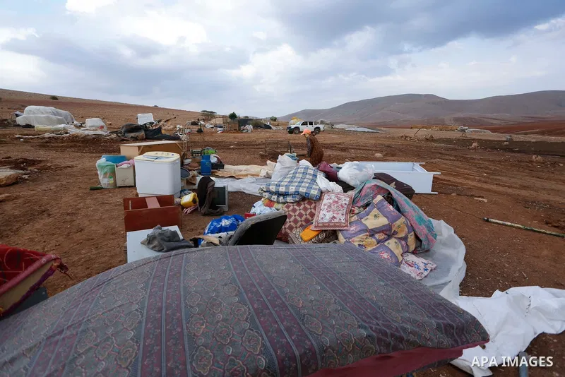 Palestinian bedouins stand next to their belongings after Israeli soldiers demolished their tents in an area east of the village of Tubas, in the West Bank, on November 3, 2020. Photo by Shadi Jarar'ah