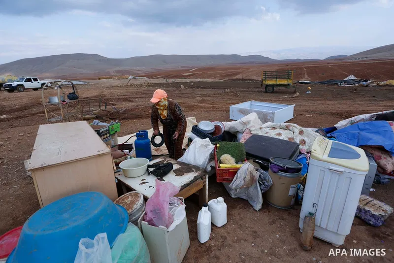 Palestinian bedouins stand next to their belongings after Israeli soldiers demolished their tents in an area east of the village of Tubas, in the West Bank, on November 3, 2020. Photo by Shadi Jarar'ah