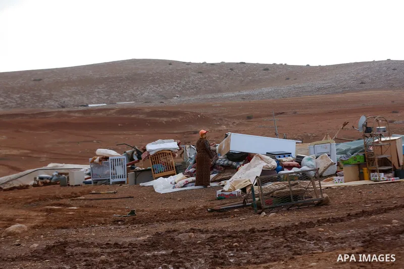 Palestinian bedouins stand next to their belongings after Israeli soldiers demolished their tents in an area east of the village of Tubas, in the West Bank, on November 3, 2020. Photo by Shadi Jarar'ah
