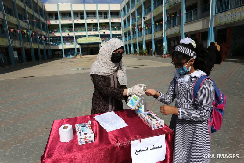 Palestinian students wearing protective face masks, as schools gradually reopen amid the coronavirus disease (COVID-19) outbreak, at their school run by the United Nations Relief and Works Agency (UNRWA) in Khan Younis i...