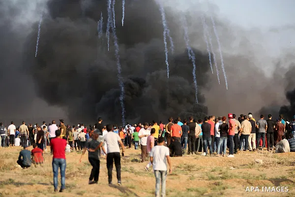 Palestinian protesters gather during clashes with Israeli troops in tents protest where Palestinian demand the right to return to their homeland at the Israel-Gaza border, in east of Gaza City on July 13, 2018. Photo by...
