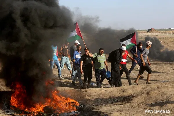 Palestinian protesters gather during clashes with Israeli troops in tents protest where Palestinian demand the right to return to their homeland at the Israel-Gaza border, in east of Gaza City on July 6, 2018. Photo by A...