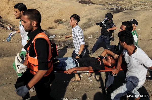 A wounded Palestinian protester is evacuated during clashes with Israeli troops in tents protest where Palestinian demand the right to return to their homeland at the Israel-Gaza border, in east of Gaza City on July 6, 2...