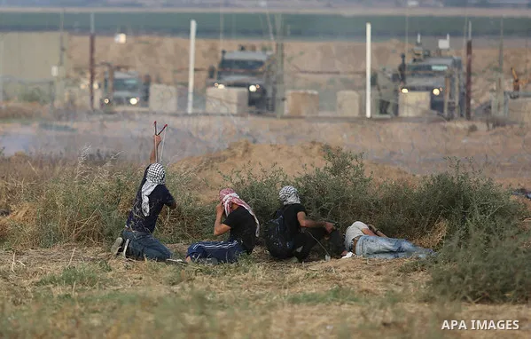 Palestinian protesters gather during clashes with Israeli security froces in a tent city protest where Palestinians demand the right to return to their homeland and against U.S. embassy move to Jerusalem at the Israel-Ga...