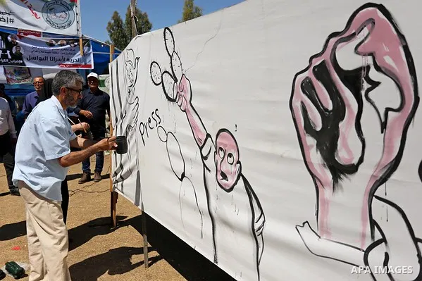 A Palestinian artist paints a mural in solidarity with Palestinian prisoners on hunger strike in Israeli jails, and to commemorate the 68th anniversary of the "Nakba" or "catastrophe" in Arabic in reference to the establ...