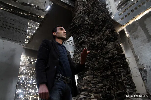 A Palestinian man helps Dutch artist Marjan Teeuwen (not seen) as she creates an architectural work that involves re-assembling wreckage of a house, that was destroyed during 2014, and turning it into artistic structures...
