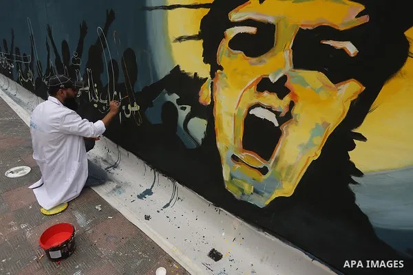 Palestinian artists draw a mural on the wall to mark the International Youth Day, in Gaza city, on Sep. 09, 2015. Photo by Mohammed Asad