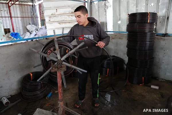 A Palestinian worker reuses plastics and metals to produce water hoses at a factory, in Gaza city, February 22, 2017. Workers collect the household recyclables, metals and plastic from landfill and garbage to sell to the...