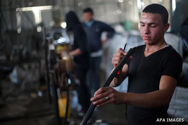 A Palestinian worker reuses plastics and metals to produce water hoses at a factory, in Gaza city, February 22, 2017. Workers collect the household recyclables, metals and plastic from landfill and garbage to sell to the...