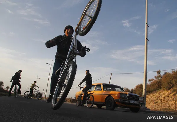 Palestinian youths display acrobatic skills on their bicycles during the weekly sport event, in the al-Zahra town, southern Gaza city, on Jan. 19, 2013. Photo by Ezz al-Zanoon
