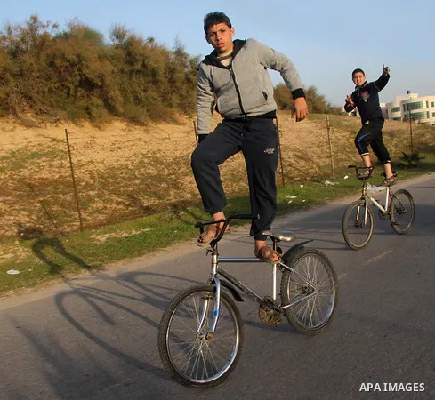 Palestinian youths display acrobatic skills on their bicycles during the weekly sport event, in the al-Zahra town, southern Gaza city, on Jan. 19, 2013. Photo by Ezz al-Zanoon