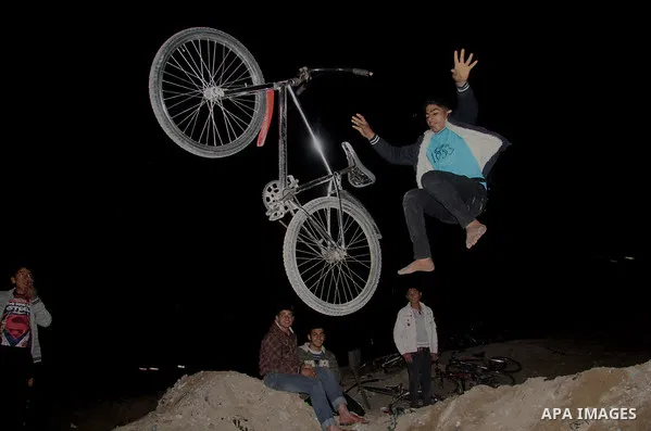 A Palestinian youth displays acrobatic skills on his bicycle during the weekly sport event, in the al-Zahra town, southern Gaza city, on Jan. 19, 2013. Photo by Ezz al-Zanoon