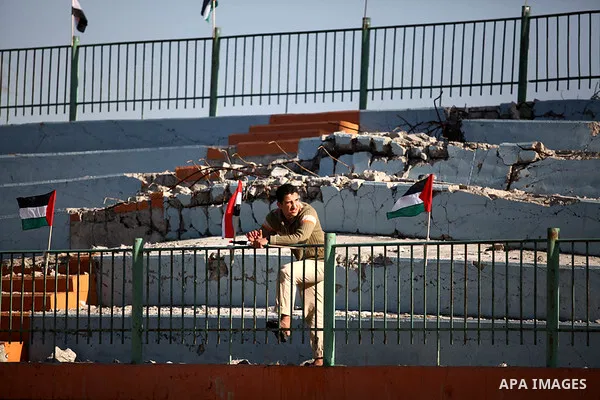 Palestinians watch as Palestinian Prime Minister in Gaza strip Ismail Haniyeh plays football with the Egyptian sport delegation, in Gaza city on 13 January 2013. The Egyptian minister of sports, Al-Ameri Farouk, arrived...