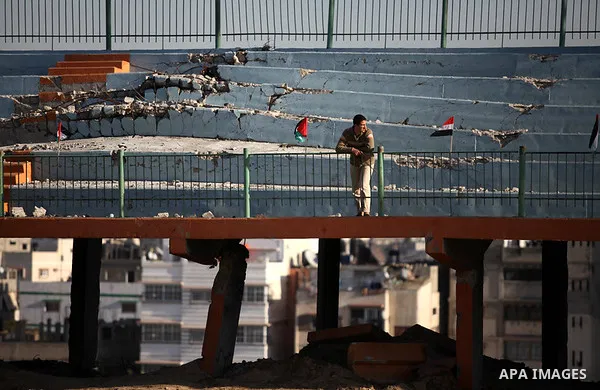Palestinians watch as Palestinian Prime Minister in Gaza strip Ismail Haniyeh plays football with the Egyptian sport delegation, in Gaza city on 13 January 2013. The Egyptian minister of sports, Al-Ameri Farouk, arrived...