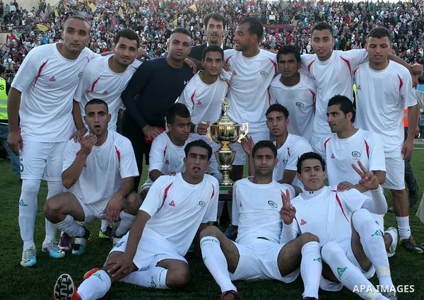 Palestinian players celebrate after the winning during a friendly football match between the Palestinian and Italian Olympic teams to mark the inauguration of the Dura Stadium near the West Bank city of Hebron on June 12...