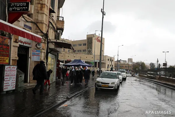 Palestinians walk in a street during a rainy day in Jerusalem's old city on January 21, 2020. Photo by Muhammed Qarout Idkaidek