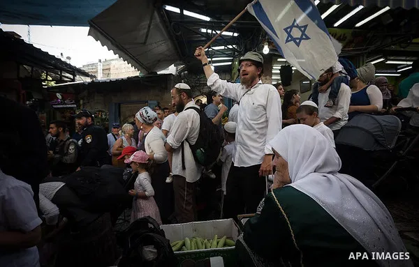Jews wave Israeli flags as they participate in a march marking "Jerusalem Day", in Jerusalem's Old City June 2, 2019. Afif Amera/WAFA