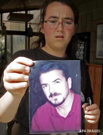 A Barbados national, Moira Joulani carries the picture of her husband Zeyad Joulani during his funeral, in the east Jerusalem neighborhood of Shufat, Friday, June 11, 2010. Israeli police shot and killed Joulani, a Pales...