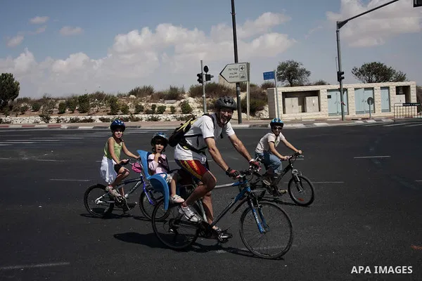 Children and adults ride their bicycle down an empty street in an East Jerusalem neighborhood on Yom Kippur, the Day of Atonement, Jerusalem, Israel on 28 September 2009. Yom Kippur is the holiest and most solemn in the...