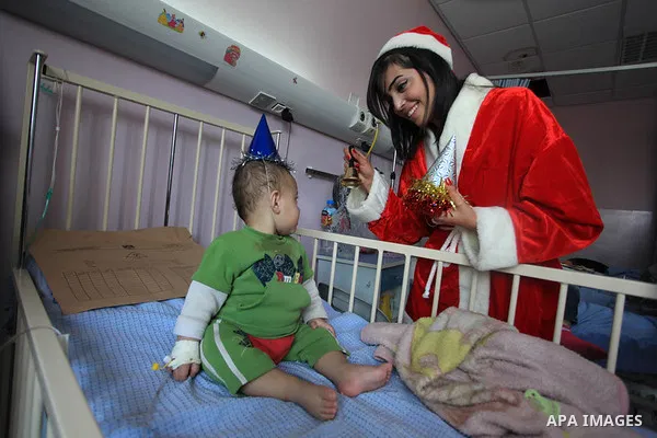 Palestinians wearing Santa Claus costumes deliver Christmas gifts to sick children at Palestine Medical Compound in the West Bank city of Ramallah, on 28 December 2013. Photo by Issam Rimawi