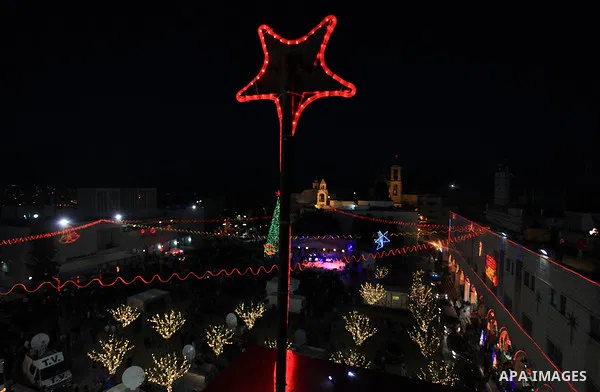 Christians take part in the Christmas celebrations outside the Church of the Nativity in the West Bank city of Bethlehem, on December 24, 2013. Thousands of Palestinians and tourists flocked into the West Bank city of Be...