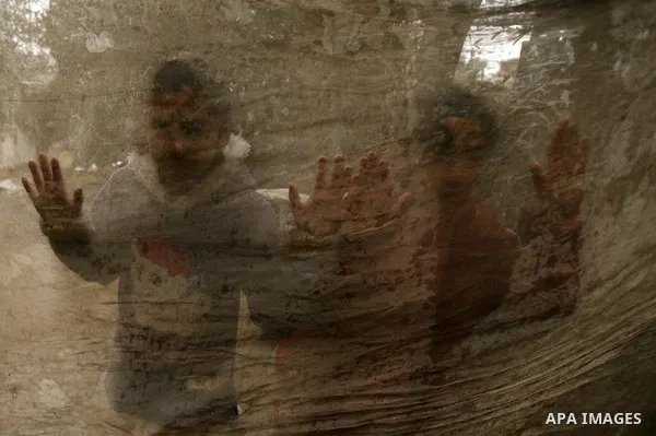 Palestinian children pose for a photograph in a school after being evacuated from their houses that are flooded with rainwater, on a stormy day in Khan Younis in the southern Gaza Strip December 14, 2013. A severe winter...