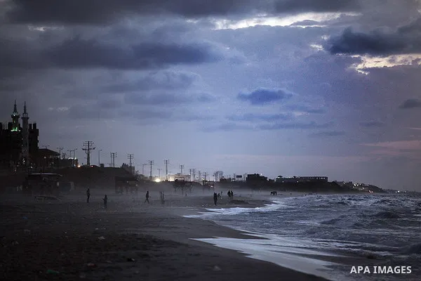 Palestinians walk on the beach of Gaza City on 28, 2013. The UN started distributing fuel in Gaza to maintain operations of critical facilities amid fears of a health crisis due to gathering garbage and sewage, Robert Se...