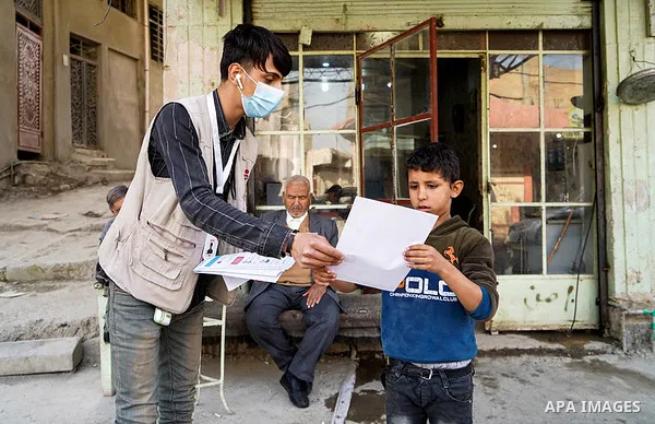 Iraqis look on the posters during awareness campaign about the coronavirus disease (COVID-19) in the northern Iraqi city of Mosul, on February 26. 2020. Photo by Ismail Adnan