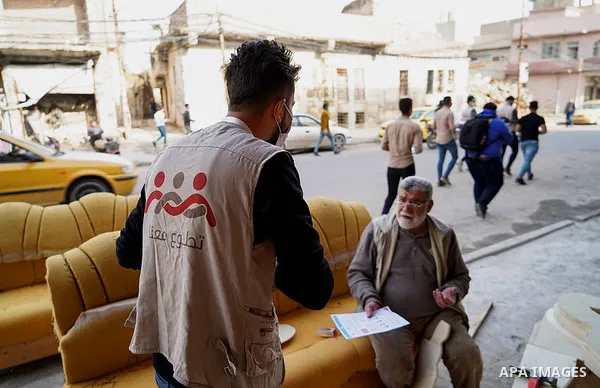 Iraqis look on the posters during awareness campaign about the coronavirus disease (COVID-19) in the northern Iraqi city of Mosul, on February 26. 2020. Photo by Ismail Adnan