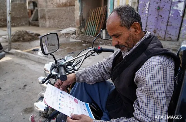 Iraqis look on the posters during awareness campaign about the coronavirus disease (COVID-19) in the northern Iraqi city of Mosul, on February 26. 2020. Photo by Ismail Adnan