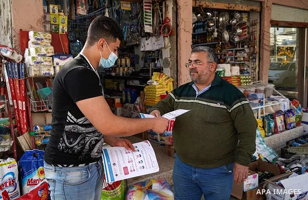 Iraqis look on the posters during awareness campaign about the coronavirus disease (COVID-19) in the northern Iraqi city of Mosul, on February 26. 2020. Photo by Ismail Adnan