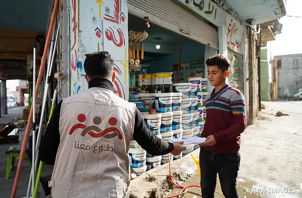 Iraqis look on the posters during awareness campaign about the coronavirus disease (COVID-19) in the northern Iraqi city of Mosul, on February 26. 2020. Photo by Ismail Adnan