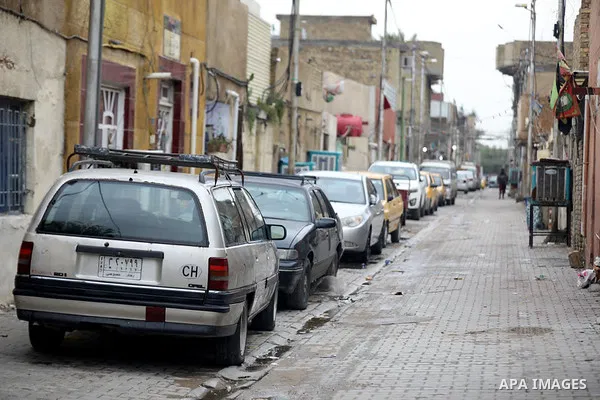 Iraqis walk past shops that are shuttered to help prevent the spread of the coronavirus, in Baghdad, Iraq, on March 21, 2020. Iraq announced a weeklong curfew to help fight the COVID-19 pandemic. Photo by Hassani Al-Asad...
