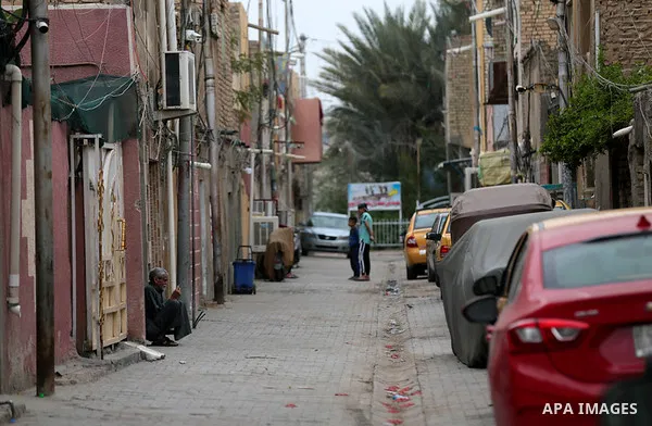 Iraqis walk past shops that are shuttered to help prevent the spread of the coronavirus, in Baghdad, Iraq, on March 21, 2020. Iraq announced a weeklong curfew to help fight the COVID-19 pandemic. Photo by Hassani Al-Asad...