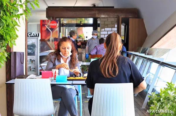 Turks, some wearing masks as a precaution against the spread of the coronavirus disease (COVID-19), sit in cafes, after the decision to open restaurants, cafes, cafeterias and public places in Istanbul, Turkey on June 3,...
