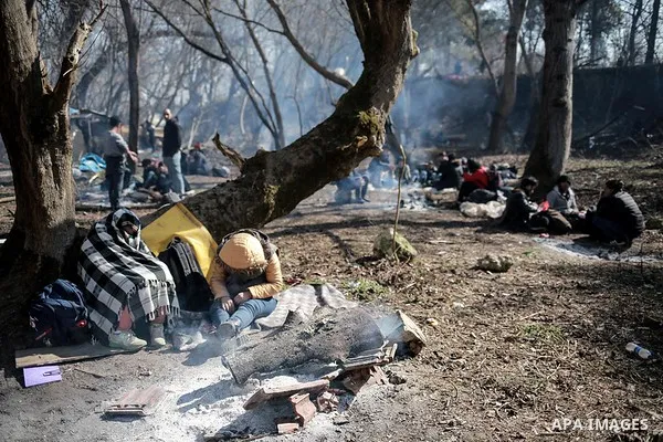 A picture taken on March 1, 2020. Refugees sit in a field near the Pazarkule gate in Edirne region, at the Turkish-Greek border. Migrants and refugees hoping to enter Greece from Turkey appeared to be fanning out across...