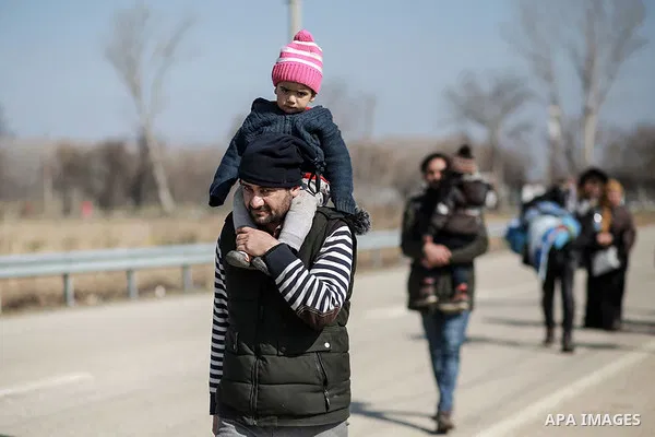 A picture taken on March 1, 2020. Refugees sit in a field near the Pazarkule gate in Edirne region, at the Turkish-Greek border. Migrants and refugees hoping to enter Greece from Turkey appeared to be fanning out across...