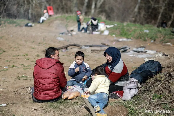A picture taken on March 1, 2020. Refugees sit in a field near the Pazarkule gate in Edirne region, at the Turkish-Greek border. Migrants and refugees hoping to enter Greece from Turkey appeared to be fanning out across...