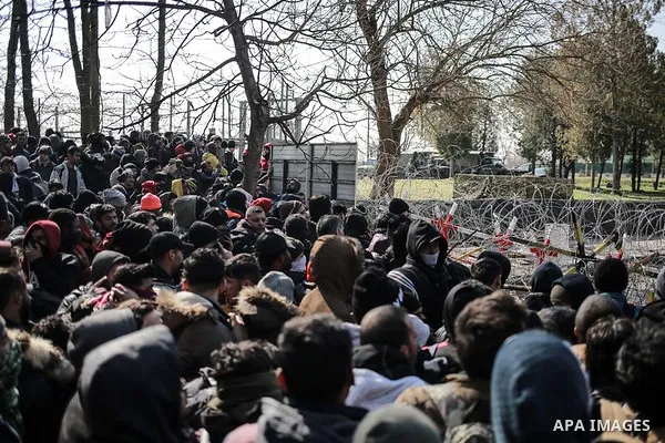 A picture taken on March 1, 2020. Refugees sit in a field near the Pazarkule gate in Edirne region, at the Turkish-Greek border. Migrants and refugees hoping to enter Greece from Turkey appeared to be fanning out across...