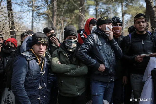 A picture taken on March 1, 2020. Refugees sit in a field near the Pazarkule gate in Edirne region, at the Turkish-Greek border. Migrants and refugees hoping to enter Greece from Turkey appeared to be fanning out across...