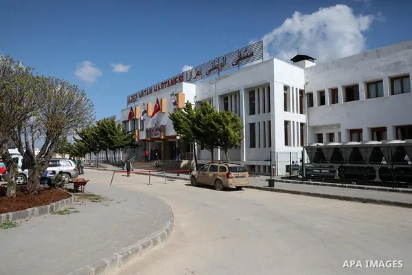 A photo taken on April 9, 2020, shows Syrian doctors put on a protective suits examine sample from a patient at the Mobile test center for suspected coronavirus outside the National Hospital in the northern Syrian city o...