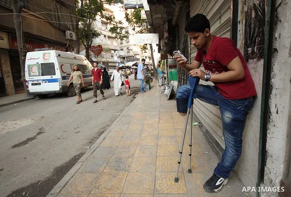 Nour, a 18-year-old Syrian man, stands in a street in a rebel-controlled area of Aleppo, on August 13, 2015. Nour lost his leg following a bomb barrel attack by forces of Syria's President Bashar al-Assad near his house...