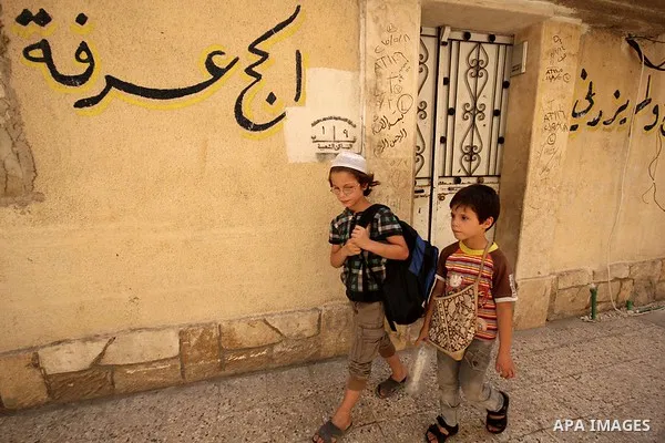 Fouad, a 11-year-old Syrian boy, walks on his way to school in a rebel-controlled area of Aleppo, on August 8, 2015. Fouad works everyday following the school time to provide for his small family, as his father suffers f...