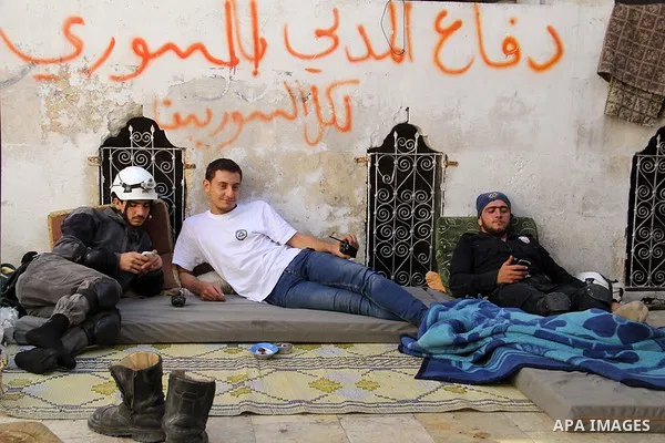 Members of Syrian civil defense, sit in a street in a street in Bab al-Nairab district in the northern Syrian city of Aleppo, June 26, 2015. Some 600 Syrians known as ''White Helmets'' or Syrian Civil Defense units, are...